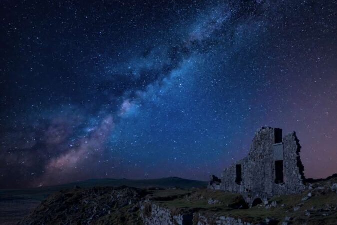 The glowing Milky Way stretching across a dark blue night sky filled with stars, captured in stunning astrophotography.