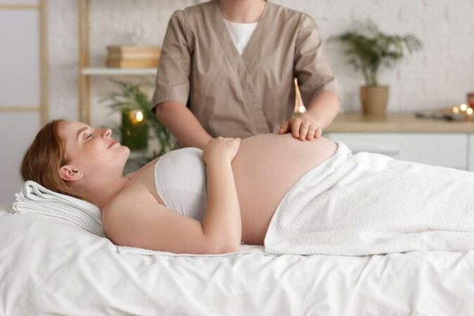 A pregnant woman relaxing on a treatment table during specialized Prenatal Massages